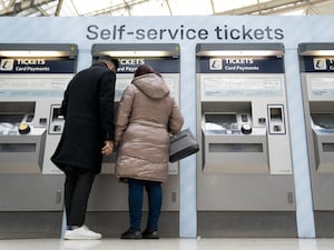 People using a ticket machine at Waterloo train station in London