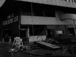 Black and white photo of the outside of the Mulberry Bush pub after the bombing