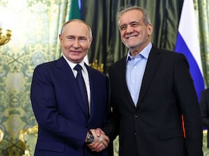 Mr Putin and his Iranian counterpart shake hands