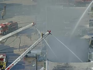 Firefighters spray water on the Plaza Latina shopping centre