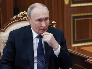 Vladimir Putin sitting in a chair