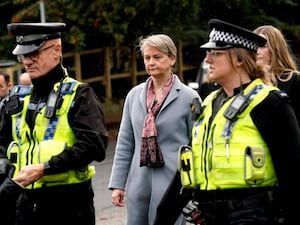 Yvette Cooper walking with uniformed police officers on a visit to Halifax in Yorkshire.