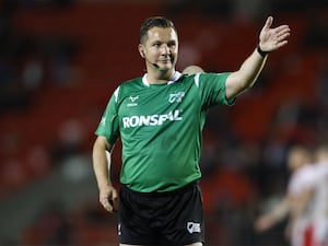 Ben Thaler holds his arm up as he referees a game