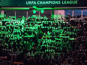 Celtic fans hold up scarves