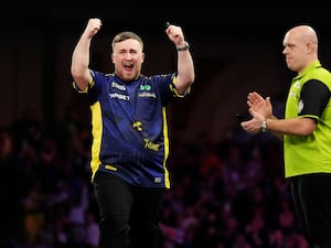 Luke Littler, left, celebrates on stage next to Michael van Gerwen