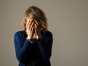 Woman with her hands over her face