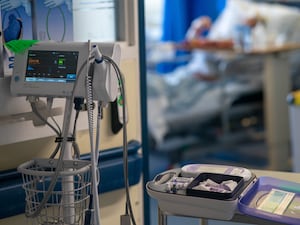 Hospital equipment outside a room with a patient's bed