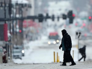 Pedestrians cross a snowy street in downtown Kansas City, US as a winter storm passed through the area