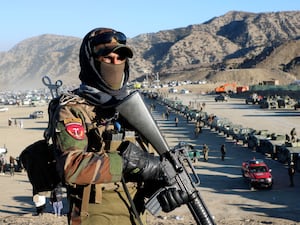 Armed man overlooking a road in Afghanistan