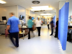 Nurses and doctors walk through a hospital ward