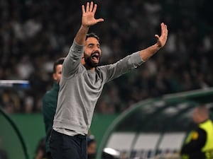 Ruben Amorim raises both arms in the air stood on the touchline