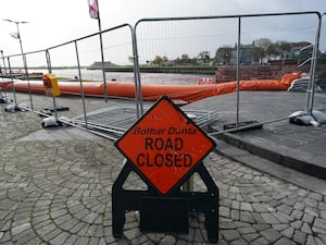 A road sign and flood defence