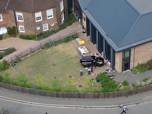 Photograph from above showing a car crashed into a building