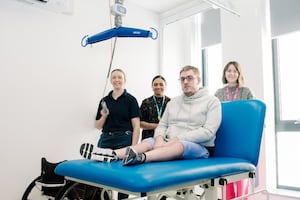 Patient Phillip Turner using the new equipment with members of the Neuromuscular Team and Heather Thomas-Bache, Head of Fundraising, Communications and Volunteers for the League of Friends.