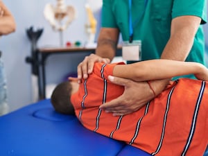 A child having physiotherapy on their back