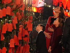 The Princess of Wales, Princess Charlotte and Prince Louis look at messages on the kindness tree