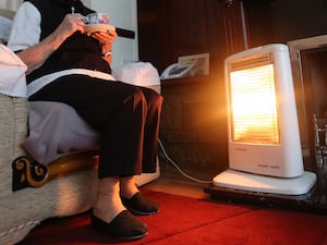 Elderly woman in front of heating