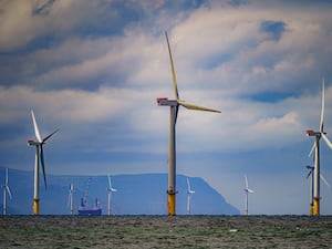 An offshore wind farm with a ship in the background