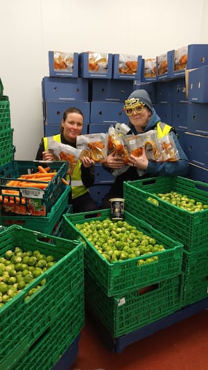 Amy Howard and Sam Pitch from Shrewsbury Food Hub with trays full of leftover Christmas food