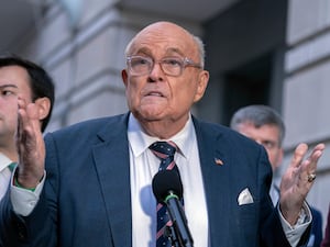 Rudy Giuliani gesturing as he speaks to reporters