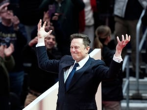 Elon Musk arrives on stage to speak at an indoor presidential inauguration parade event in Washington