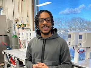 Manny Wallace, known as Big Manny on TikTok, smiling and standing inside a science lab