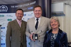 Thomas McGeever receives his Medal of Honour from TV personality Matt Allwright and Specsavers' founder Dame Mary Perkins.