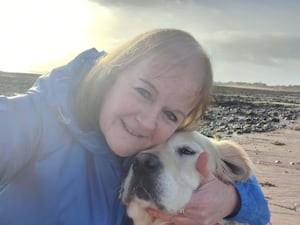 Andrea Phillips hugs golden retriever Seren