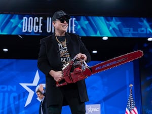 Elon Musk holding a chainsaw