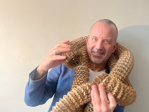 A man wearing an origami art piece around his neck