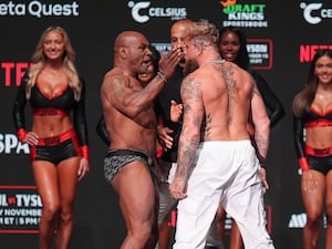 Mike Tyson (left) slaps Jake Paul during a weigh-in ahead of their heavyweight bout