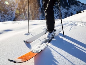 A close up of a man skiing on fresh snow