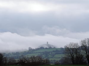 People in the foggy conditions at St Michael’s Tower on top of Glastonbury Tor, Somerset