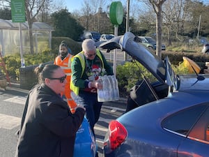 A helper loads a car at a bottle station at Asda, Totton