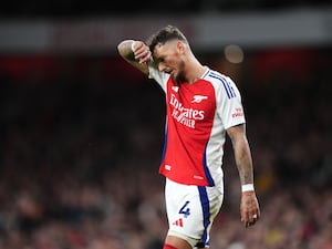 Arsenal’s Ben White wipes sweat from his forehead with his hand