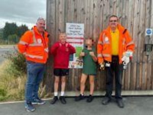 Pupils at Ysgol Gymraeg Y Trallwng in Welshpool help the road safety officers, Jim Campbell and Rob Griffith, ensure the new sign is at the correct height, so parents can stand their children against the height chart and see what car seat they should be using to stay safe.