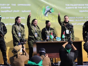 Female Israeli soldiers wave from a podium