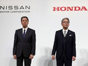 Nissan chief Executive Makoto Uchida, left, with Honda chief executive Toshihiro Mibe during a joint news conference in Tokyo in December