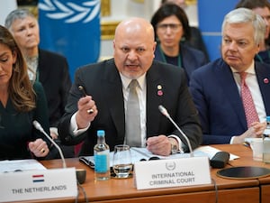 Karim Khan speaking into a microphone at a desk