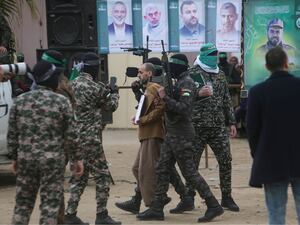 Eli Sharabi is escorted by Hamas fighters