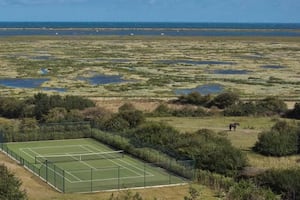 The all-weather tennis court is situated away from the house, close to the Norfolk Coastal Path | Omaze