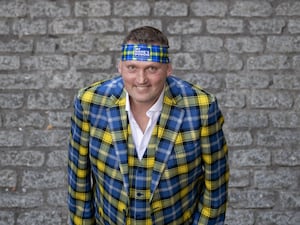 Doddie Weir dressed in the My Name'5 Doddie Foundation tartan, smiling at the camera