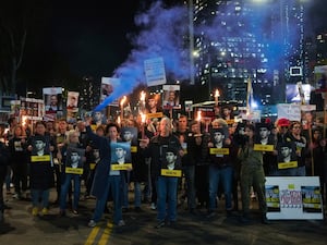 Demonstrators hold torches during a protest in Tel Aviv calling for the immediate release of hostages held in the Gaza Strip by Hamas