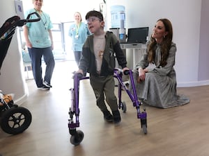 The Princess of Wales kneels down to meet a youngster at Ty Hagan Children's Hospice near Cardiff