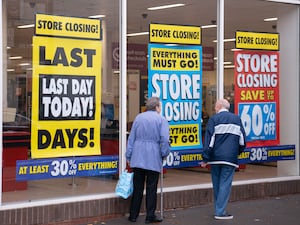 Customers walk past a store closing down