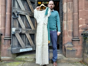 Dr Robert MacKinnon from Soldiers of Shropshire Museum holds up Joan
Crooke’s army dress at the entrance to Shrewsbury Castle.