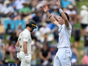 Matthew Potts raises both arms to celebrate a wicket