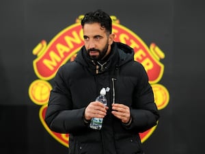 Ruben Amorim stands in front of the Manchester United crest