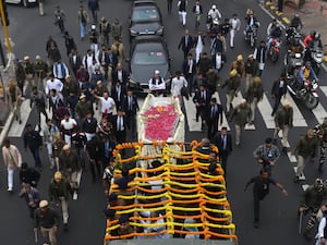 Mourners march alongside a coffin