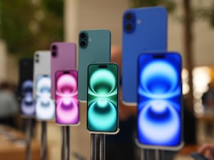 A number of Apple iPhones in different colours on display in a central London store